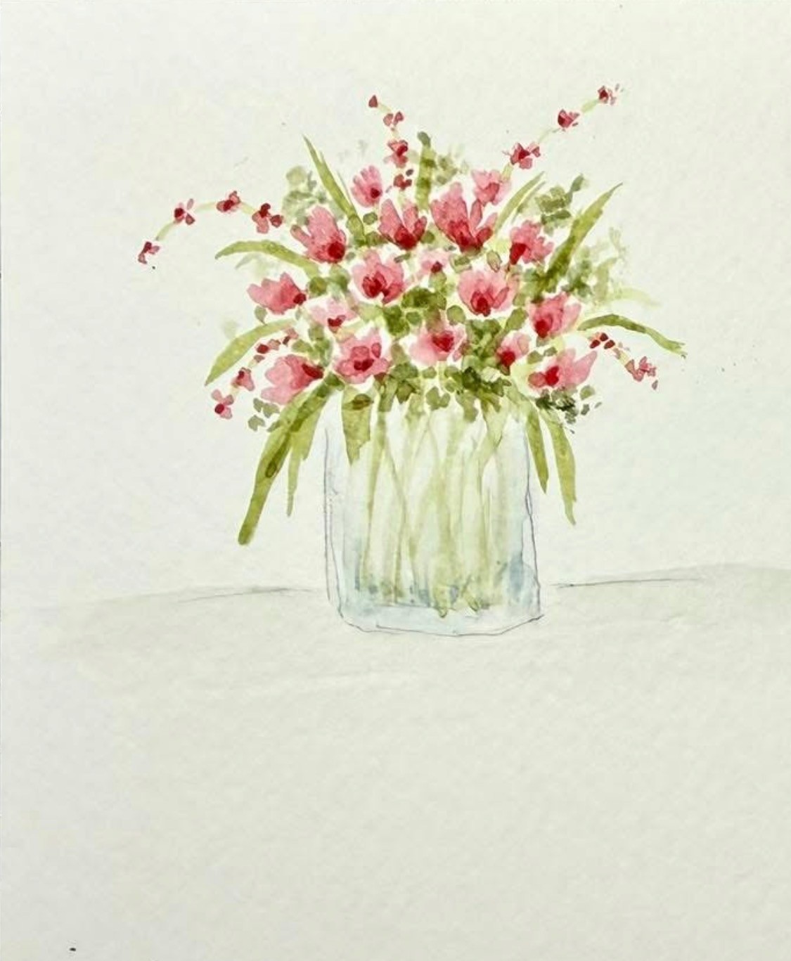 Loose pink flowers and green foliage in a glass jar
