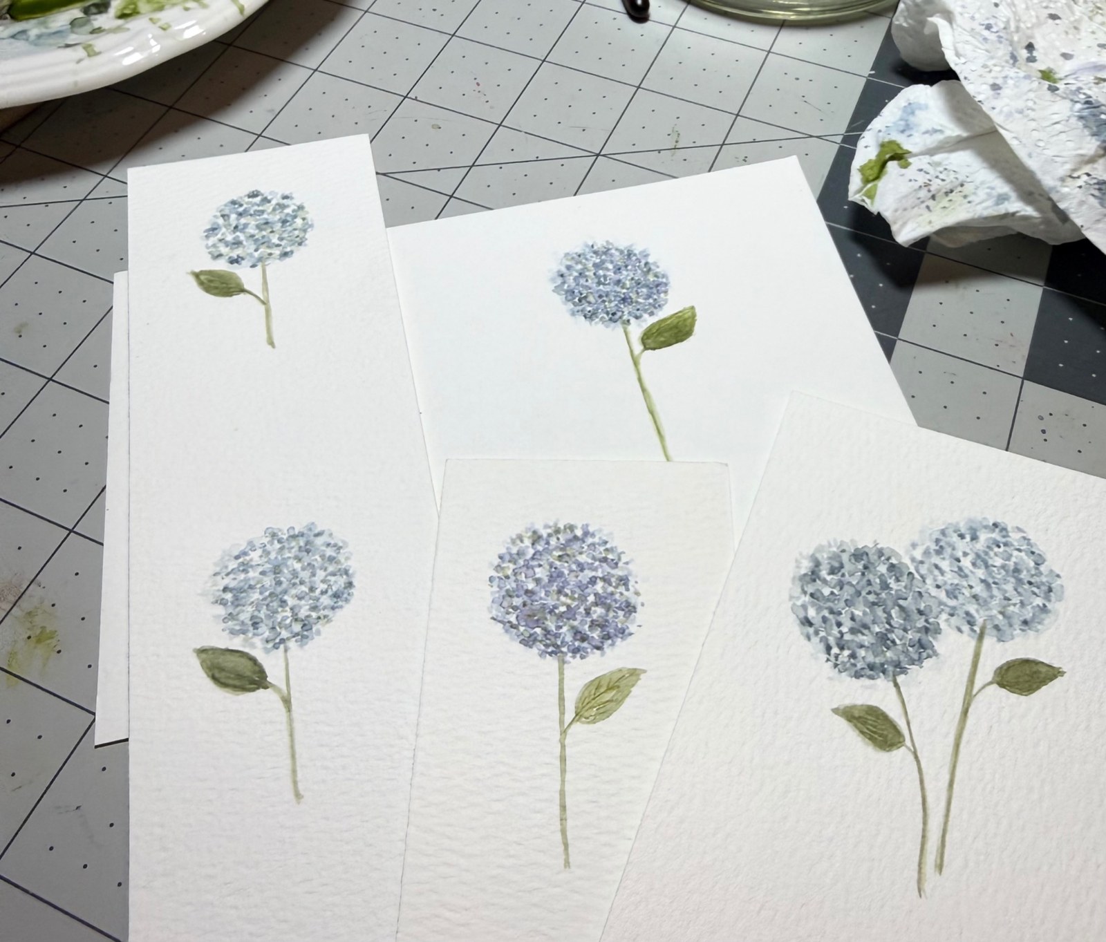 Blue hydrangea studies arranged on the painting table