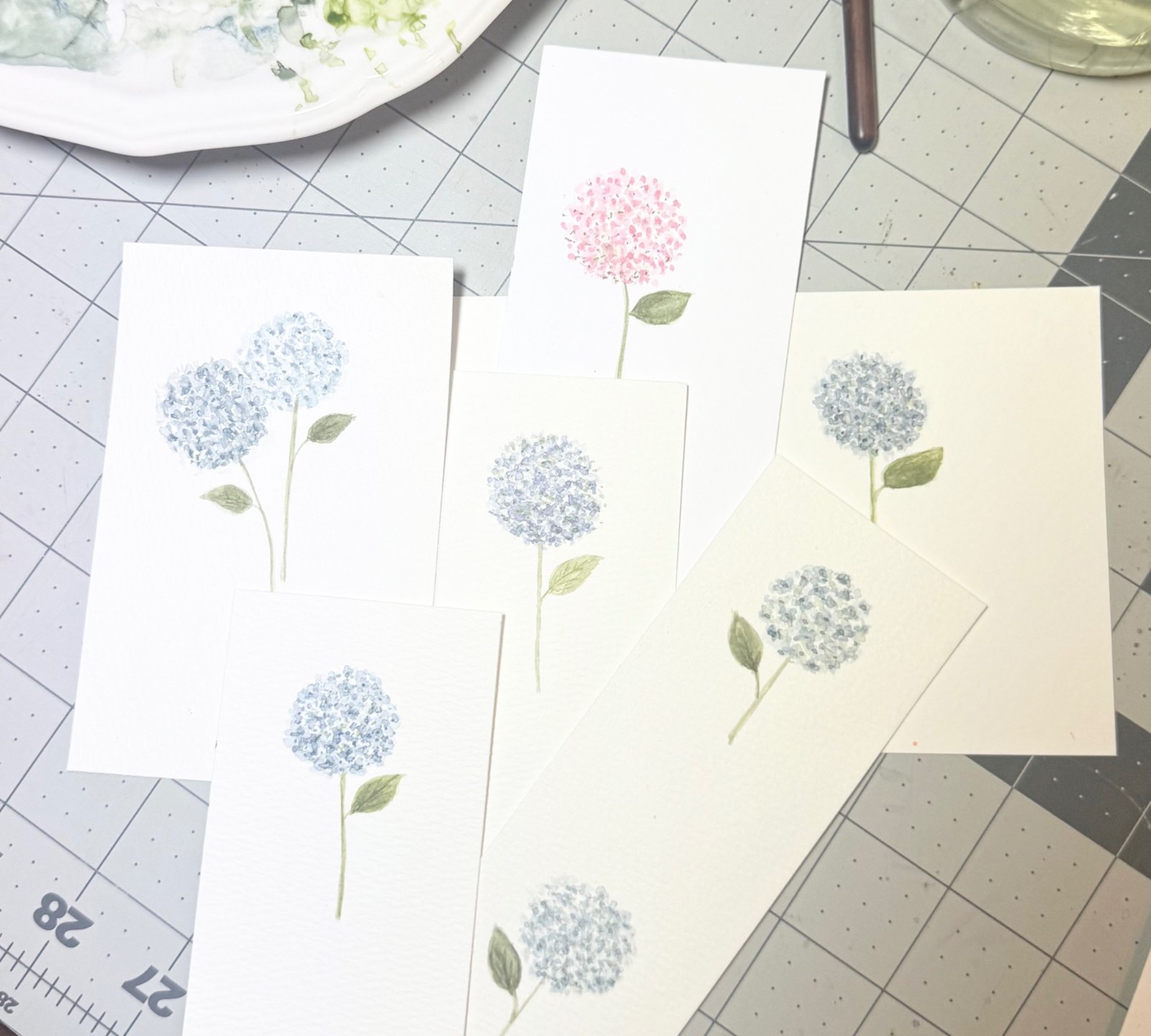 Watercolor hydrangeas arranged on a cutting mat