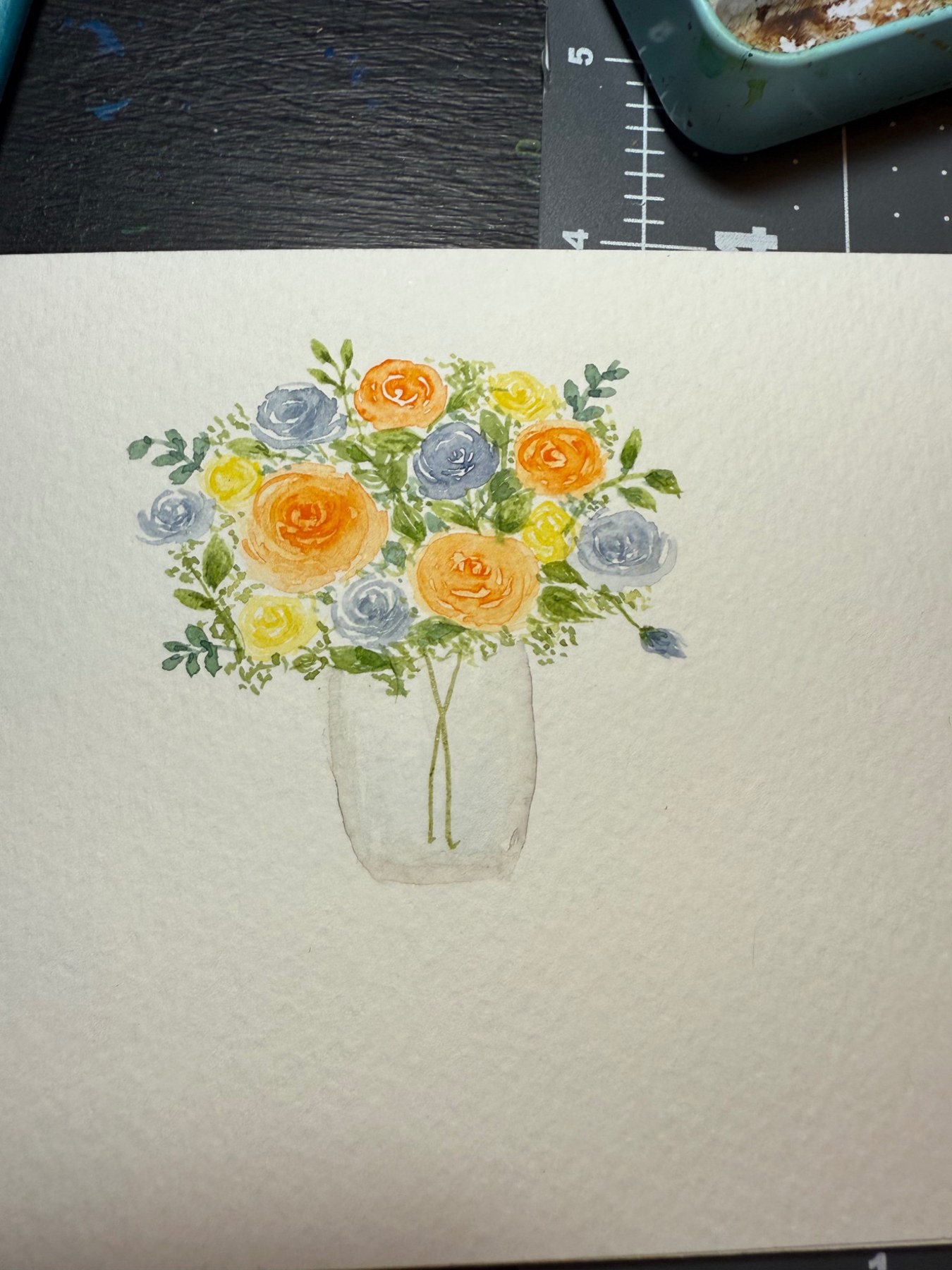 Yellow roses and blue flowers in a glass jar