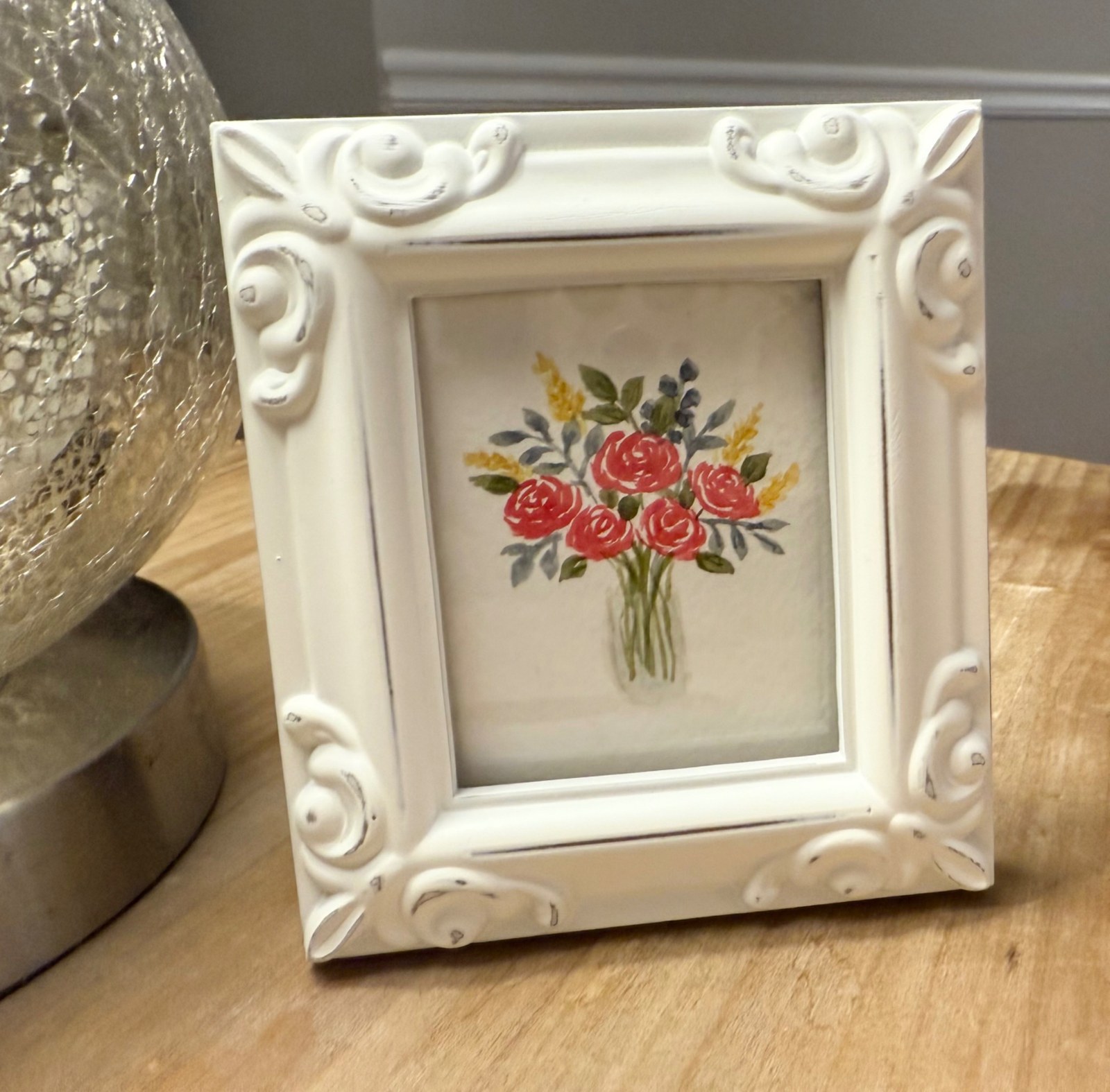 Rose watercolor displayed in an ornate white frame