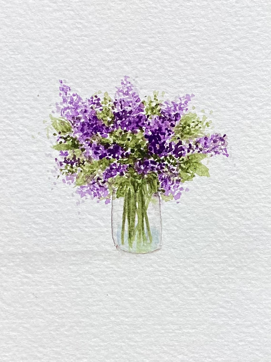 Purple lilac flowers in a glass vase
